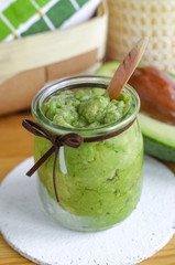 Homemade avocado mask in a glass jar. Prepared from mashed avocado and olive oil. Diy cosmetics. 