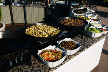 Fried vegetables in black frying pans