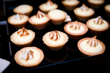 Baked baskets with cream on black glass tray