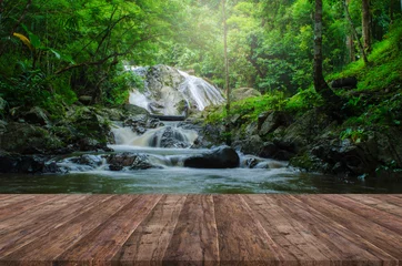 Schilderijen op glas Wood floor perspective and natural mountain waterfall © leekaomeng