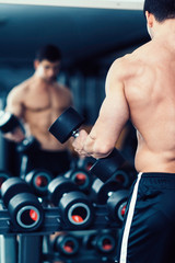 Fototapeta na wymiar Muscular man exercising in the gym