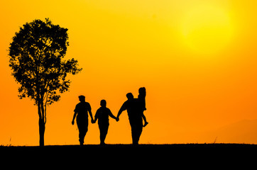 Fototapeta na wymiar silhouette family over grass background at sunset