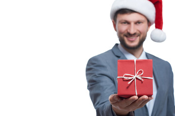 Happy man in a Christmas hat holding a present