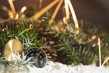 Compass on snow with winter holidays decoration in background 