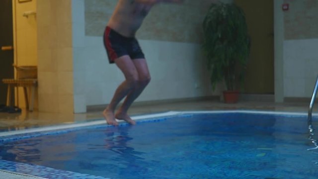 a man jumping in the pool
