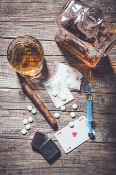 Hard drugs and alcohol on an old wooden table. Top view