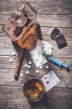 Hard drugs and alcohol on an old wooden table