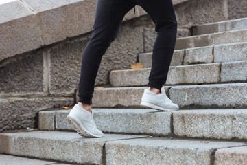 Man legs running on stairs outdoors