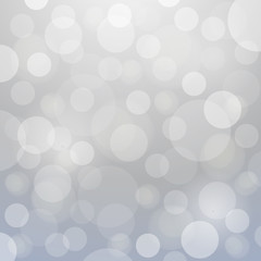 Glowing silver bokeh background for christmas designs.
