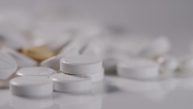 4K Health care concept shot of mixture of medications with rolling empty pill bottle 
