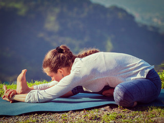 Woman doing Ashtanga Vinyasa yoga Janu Sirsasana A asana stretch