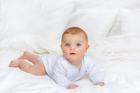 Baby in white bedding.