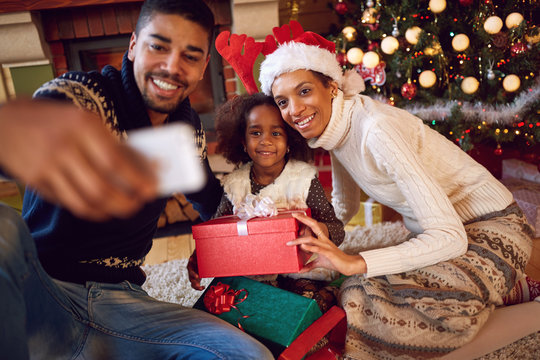 Happy family taking self portrait with smartphone during Christm