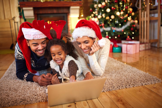 Afro American family use laptop for Christmas shopping online