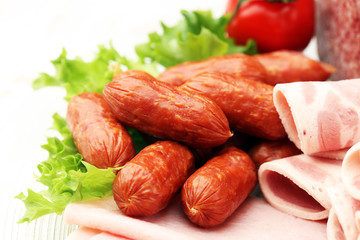 Food tray with delicious salami, pieces of sliced ham, sausage, tomatoes, salad and vegetable - Meat platter with selection - Cutting sausage and cured meat on a celebratory table.