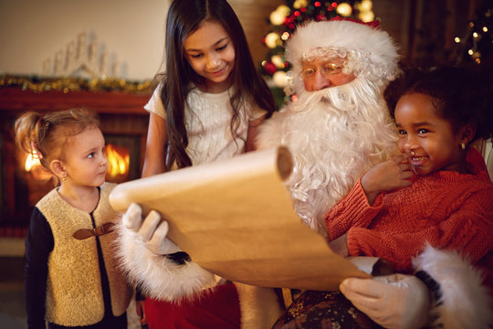 Group of little multi ethnic girls looking in Santa Claus with w
