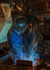 Worker with protective mask welding metal