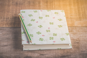 Closeup of handmade book and pencil on wooden background