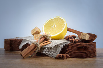 set lemon, anise, cinnamon, brown sugar on old wooden Board isolated and light background