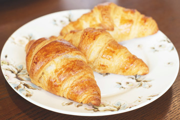 three butter croissant on vintage dish