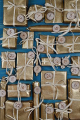 Advent calendar with twenty four golden presents on teal wood