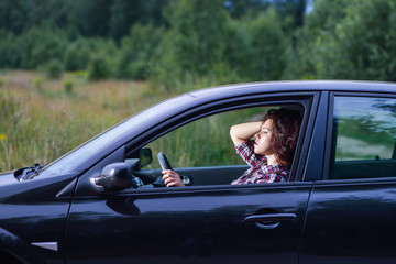 Fototapeta na wymiar Side portrait of young woman driving a car
