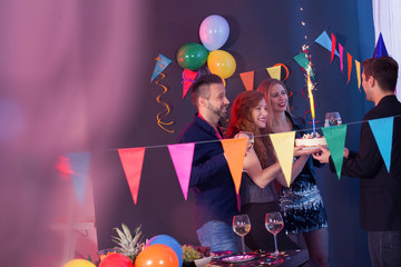 Young people giving birthday cake