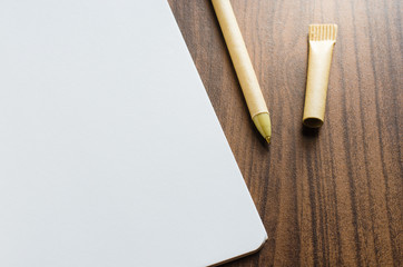 blank recycled notebook and pen on the wood table.