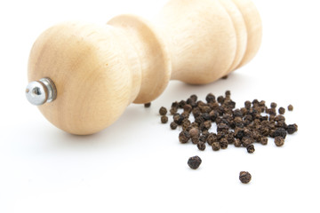 pepper mill of wood with peppercorns