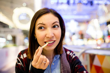 Beautiful caucasian young woman eating lunch fast food fried potato in cafe at shopping mall.