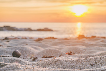 Beautiful seascape. Sea, sand with footsteps and rock at the sunset. Nature composition. Thai beach in sunset time in Koh Chang island, Thailand. Selective focus