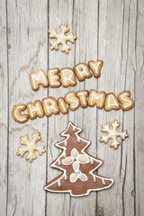 Weihnachtlicher grauer Holz Hintergrund mit Lebkuchen und Merry Christmas
