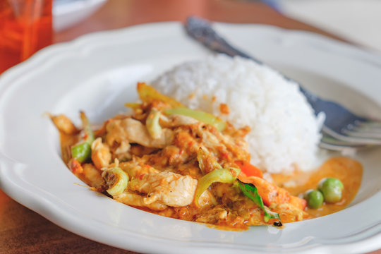 Thai cuisine, chicken curry closeup with rice on the blurred cafe background.