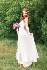 Obraz na płótnie Canvas Beautiful bride in white dress in the garden