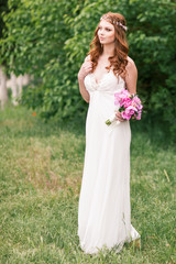 Fototapeta na wymiar Beautiful bride in white dress in the garden