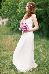 Fototapeta na wymiar Beautiful bride in white dress in the garden