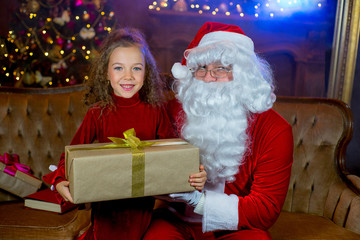Fototapeta na wymiar Santa Claus and girl with Christmas gifts