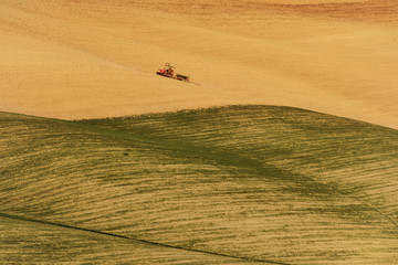 Obraz premium Farm tractor on the field in Europe at autumn, natural seasonal agriculture background