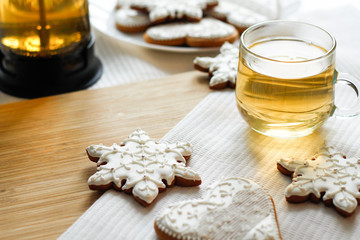 A cup of tea on the tablecloth with gingerbread