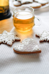 A cup of green tea on the tablecloth with gingerbread