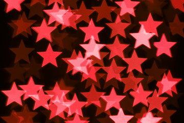 Fototapeta na wymiar Abstract star shaped bokeh background. Defocused background with red stars