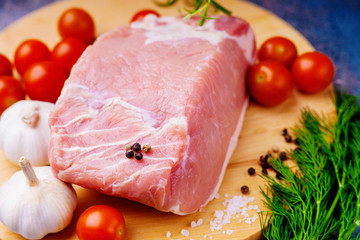 Raw pork on cutting board and vegetables