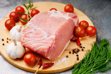 Raw pork on cutting board and vegetables