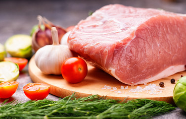 Raw pork on cutting board and vegetables 