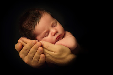 Newborn Baby taken closeup in father's Hand - black and white