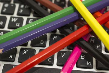 Цветные карандаши рассыпаны на клавиатуре