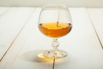 glass of brandy on a white wooden table