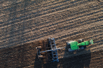 Naklejka premium aerial view of harvest fields with tractor in Poland