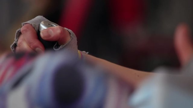 Woman is doing I-sits during workout in the gym. Close-up of hands on the parallel bar.