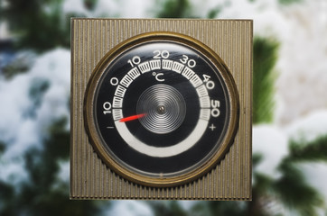 Ice cold thermometer. subzero. snow on a tree